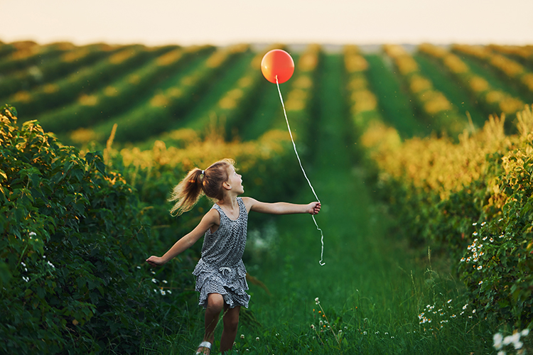 En glad lille pige med ballon